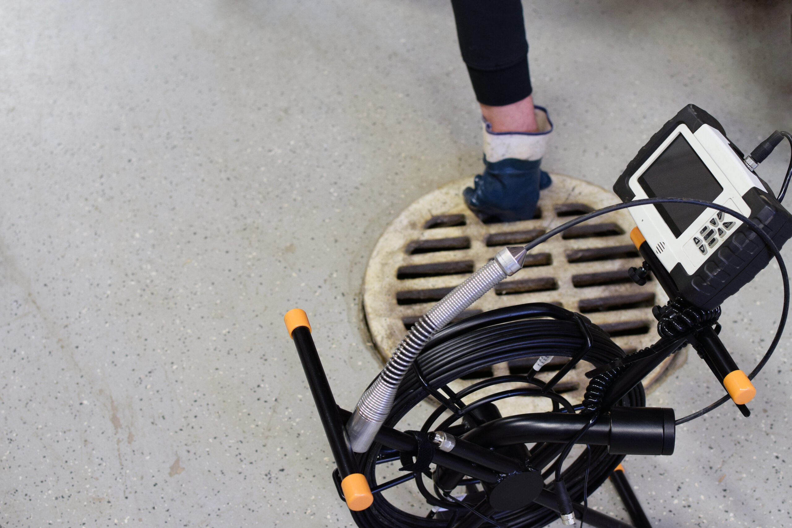Sewer inspection camera. Man removing drainage grill on background. New Construction Home Inspection Services